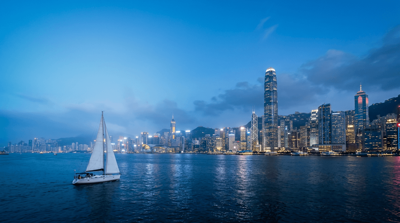 香港維多利亞港夜景，海面上有一艘揚帆的白色帆船